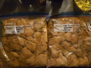 Two gallon-size freezer bags, containing cut up chicken and marinade, ready to be frozen for later use.